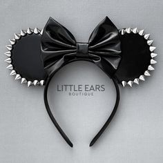 a minnie mouse ears headband with spikes and a bow on it's side