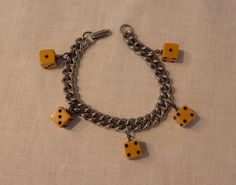 Gals, this fabulous bracelet is sure to make you feel like one lucky lady! An original vintage charm bracelet circa 1940s or 1950s, its a classic warm toned silver colour metal link chain bracelet, with 5 fully finished perfectly formed dice in a rich mustard toned plastic that is likely bakelite. Ace. Ready and waiting to finish that flawless 1940s or 1950s ensemble, and bring some ultra glamourous luck along the way.  Measurements:    Length: 7 1/4" long from furthest hinge on clasp to final r Adjustable Retro Nickel-free Jewelry, Retro Metal Jewelry For Gifts, Retro Metal Jewelry For Gift, Retro Charm Bracelet As A Gift, Retro Charm Bracelet For Gift, Vintage Charm Metal Chain Bracelet As Gift, Vintage Charm Metal Chain Bracelet Gift, Vintage Metal Charm Bracelet With Chain, Vintage Metal Chain Charm Bracelet