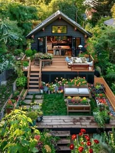 a small backyard with lots of plants and flowers on the deck, surrounded by greenery