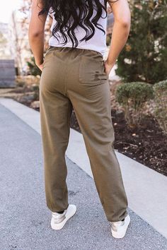 Keep your style edgy with our olive colored 'Pike' joggers featuring soft lightweight material with distressed detailing, a high waistline with a tie closure, accent side pockets, and a relaxed pants silhouette that tapers into fitted elastic band ankle-length hemlines! Sporty Khaki Pants For Fall, Fall Utility Sweatpants With Elastic Waistband, Spring Khaki Sweatpants With Side Pockets, Spring Khaki Sweatpants With Elastic Waistband, Trendy Khaki Bottoms For Loungewear, Green Fall Leisure Bottoms, Spring Cargo Style Sweatpants For Loungewear, Spring Khaki Joggers With Elastic Waistband, Casual Green Joggers For Fall