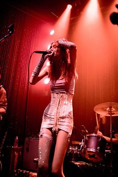 a woman on stage singing into a microphone