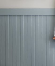 a white toilet sitting next to a bath tub in a bathroom under a window with wooden shutters