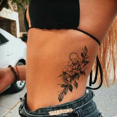 a woman with a flower tattoo on her lower back and the bottom part of her stomach