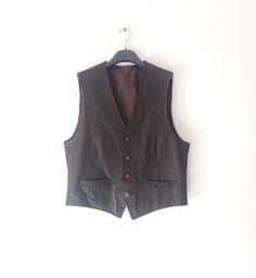 "Vintage Men's Leather Dark Brown Leather Vest/Waistcoat. Costume Vest. Groom Vest. Party Vest. Classic Vest. Size: S. Material: 100% Genuine Leather. Color: dark brown (chocolate). Fully Lined. Buttons closure. Two small pockets. Great vintage condition. Measurements lying flat and doubled where necessary. Length from shoulder to hem: 60 cm (23.62\") front. Chest ( armpit to armpit): 53 cm (20.86\") Shoulder to shoulder: 38 cm (14.96\") arm opening: 28 cm (11.02\")" Business Sleeveless Vest With Buttons, Sleeveless Business Vest With Buttons, Business Vest With Buttons For Fall, Sleeveless Business Outerwear With Button Closure, Business Vest With Button Closure For Fall, Fall Business Vest With Button Closure, Brown Workwear Vest With Buttons, Brown Vest With Button Closure For Work, Winter Business Vest With Button Closure