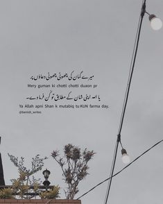 an arabic quote on the side of a building with street lights and trees in the foreground