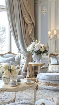 a living room filled with lots of furniture and flowers in vases on top of tables