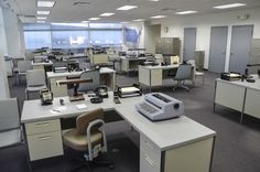 an office cubicle with several computers and desks