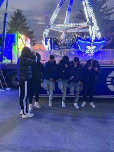 several people standing in front of a carnival ride