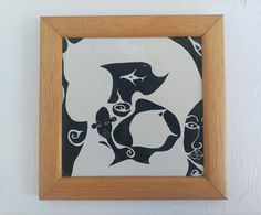 a wooden frame holding a painting with black and white designs