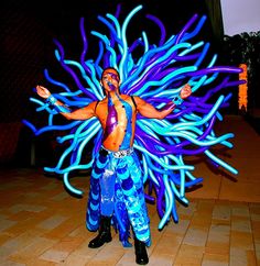 a man in blue and purple costume standing on tiled floor with his arms spread out