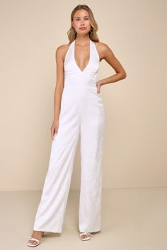 All eyes will be on you (with good reason!) when you're looking so sophisticated in the Lulus Elegant Aspect Ivory Floral Jacquard Halter Wide-Leg Jumpsuit! Lightweight woven satin boasts a chic floral jacquard design as it shapes a tying halter neckline and a bodice with seamed cups and a set-in waist. Wide legs finish at ankle-length hems. Hidden zipper/clasp and elastic at back. Fit: This garment fits true to size. Length: Floor length. Size medium measures 58" from top to bottom. Inseam: 32. Glamorous Spring Wedding Jumpsuit Or Romper, Elegant Cream Jumpsuit For Party, Elegant Cream Jumpsuits And Rompers For Party, Feminine Fitted Jumpsuit For Formal Occasions, White Jumpsuits And Rompers For Spring Wedding, Feminine Fitted Jumpsuits And Rompers For Formal Occasions, Elegant White Jumpsuit For Formal Occasions, Feminine White Jumpsuits And Rompers For Party, White Feminine Jumpsuits And Rompers For Party