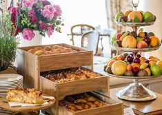 there are many different types of pastries on the trays in this table setting