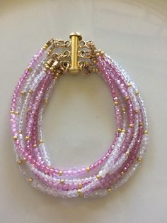 This is a multi strand bracelet with clasp. the stones are pink topaz, pink zirconia and white zirconia with tiny little gold fill beads. There are 7 strands and the components are gold filled but the clasp is gold plated. This measures just under 6 inches. ABOUT SHIPPING- Shipping within Canada is crazy expensive. If there is any overage I will refund. I'm very limited in adding different cost of shipping between provinces. I have tried different ways of listing shipping costs and this is the o Pink Multi-strand Faceted Beads Jewelry, Pink Multi-strand Jewelry With Faceted Beads, Pink Multi-strand Beaded Bracelets, Waist Beads, Bracelets Diy, Multi Strand Bracelet, Jewellery Ideas, Pink Topaz, Pink Jewelry