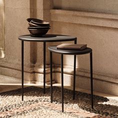 two black tables sitting next to each other on top of a rug