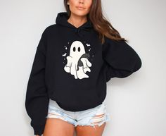 Cute Ghost Hoodie, Ghost Halloween Hoodie, Spooky Season Hoodie, Trending Halloween Hoodie, Black Cat Hoodie, Halloween Gift 💖Youth Hoodies do not have drawcord for added safety!💖 Material: 50% cotton, 50% polyester for a comfortable and durable blend. Fabric: Medium-heavy (8.0 oz/yd² or 271.25 g/m²) for warmth on cooler days. Fit: Loose fit for comfort without sacrificing style. Label: Sewn-in for a seamless feel. Sizing: Check our sizing chart for the right fit. HOW TO PLACE YOUR ORDER Revie Black Crew Neck Hoodie For Halloween, Black Long Sleeve Halloween Hoodie, Black Halloween Hoodie With Drawstring, Spooky Black Halloween Hoodie, Spooky Black Crew Neck Hoodie, Halloween Hooded Spooky Sweatshirt, Black Spooky Crew Neck Hoodie, Spooky Hooded Halloween Sweatshirt, Hooded Spooky Halloween Sweatshirt