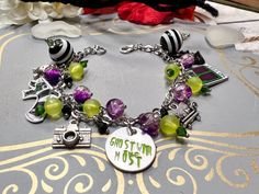 Beetlejuice bracelet has purple crackle glass beads, yellow frosted and green crystals, The end beads are black and white. The charms are a sandworm, beetle, photo, camera, house and sofa. Charms are made of shrink plastic and coated in UV resin. Bracelet is 8 inches but can be made any size. due to the handmade nature of the product there could be some variations in charms or beads but they will be as close to the photo as possible. Beetlejuice Bracelet, Beetlejuice Jewelry, Beetle Photo, Beetlejuice Fan Art, Beetlejuice Costume, Beaded Braclets, Beetle Juice, Rose Girl, Resin Bracelet