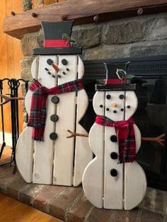 two snowmen are standing next to each other in front of a fire place and fireplace