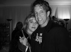 black and white photo of man and woman posing for the camera with their arms around each other