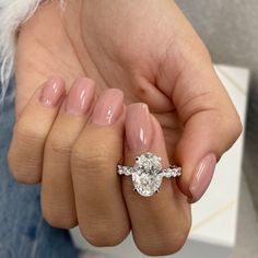 a woman's hand holding a ring with a diamond on it and two diamonds in the middle