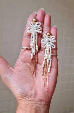 "Handmade statement Ivory pearl and gold chain floral long earrings. These handmade statement earrings are made of faux pearl flower, seed beads, and electroplated rose gold chain. The earrings are beautiful and ideal for weddings and parties. The earrings measures approx. 3\" long and 1.50\" wide. Carnation jewellery are purely handmade & handcrafted in India. Since our product is purely handmade in nature hence a slight imperfection may be there but it is almost negligible. The colors and may Statement Beaded Earrings, Elegant Pearl Drop Tassel Earrings, Gold Pearl Drop Tassel Earrings For Party, Gold Tassel Earrings With Pearl Drop For Party, Elegant Pearl Drop Tassel Earrings For Wedding, Elegant Pearl Drop Tassel Earrings For Party, Elegant Beaded Dangle Earrings With Tassels, Gold Dangle Tassel Earrings For Wedding, Gold Tassel Earrings For Wedding