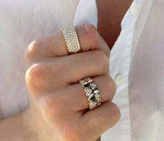 a woman's hand holding a gold ring with diamonds