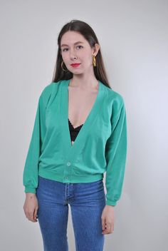 Add a touch of vintage charm to your wardrobe with this green minimalist buttons cardigan! Made from comfortable cotton, this cardigan features a unique design that is perfect for adding a retro flair to your outfit. Please note that this is a vintage item, so it may have some defects. To ensure a proper fit, please refer to the measurements below: Sleeve: 46cm / 18.11 inches (measured from armpit to end of sleeve) Width: 52cm / 20.47 inches Length: 52cm / 20.47 inches These measurements are tak Green V-neck Cardigan For Layering, Vintage V-neck Cardigan For Layering, Green Buttoned Cardigan For Layering, Green Cotton V-neck Cardigan, Trendy Green Cardigan For Layering, Retro Green V-neck Sweater, Green V-neck Cardigan With Buttons, Green Buttoned Sweater For Layering, Green V-neck Sweater With Button Closure