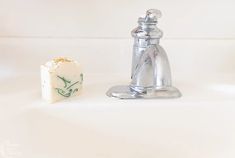 a soap dispenser next to a bar of soap on a white surface