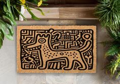 a door mat with a dog design on it next to some plants and potted plants