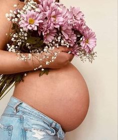 a pregnant woman with flowers in her belly is holding some baby's breathflowers