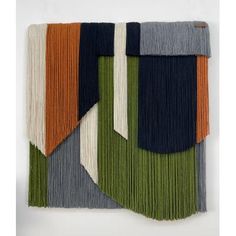 multicolored wall hanging with fringes on the side and one in the middle