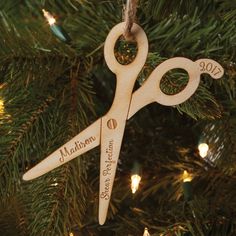 a wooden ornament hanging on a christmas tree that says madison and has scissors in it