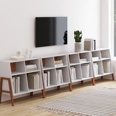 an entertainment center with bookshelves and a flat screen tv mounted on the wall