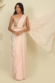 Baby pink silk woven pre-stitched and pre-draped saree. Comes with a sequins, beads, pearls and crystals embroidered blouse and a belt.
Components: 3
Pattern: Woven, Embroidered
Type Of Work: Sequins, Beads, Pearls, Crystals
Neckline: Square Neck
Sleeve Type: Sleeveless
Fabric: Silk, Lining : Shantoon
Color: Pink
Other Details: 
Attached lining
Closure : Zip and hooks
Occasion: Sangeet - Aza Fashions Baby Pink Silk, Draped Saree, Sarees Silk, Drape Saree, Blouse For Women, Fashion App, Fabric Silk, Blouse Online, Pink Silk