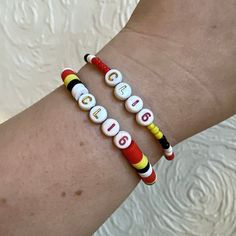 two children's bracelets with letters and numbers on them, one for each child