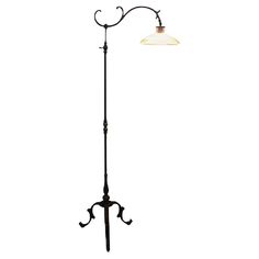 an old fashioned floor lamp with a glass shade on it's arm and base