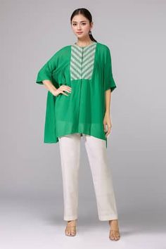 Green gathered top with metallic pearl embroidered front yoke. Comes with inner slip. - Aza Fashions Traditional Spring Workwear Tops, Traditional Embroidered Tops For Workwear, Short Sleeve Tops For Eid Festivities, Festive Short Sleeve Tops For Eid, Summer Pintucks Blouse, Green Blouse With Embroidered Neckline, Elegant Short Sleeve Top With Chikankari Embroidery, Green Blouse With Chikankari Embroidery, Green Chikankari Embroidered Tops For Eid