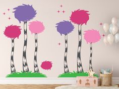 three palm trees with pink, purple and green leaves against a wall in a children's room