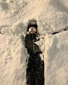 a young child is standing in the snow with his head buried in some deep snow