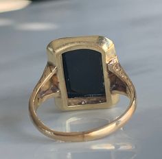 a gold ring with a black stone in it