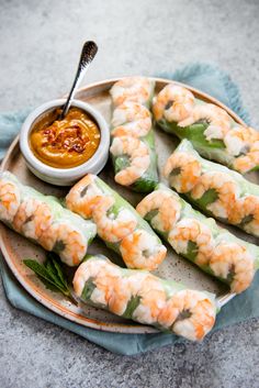 shrimp spring rolls on a plate with dipping sauce