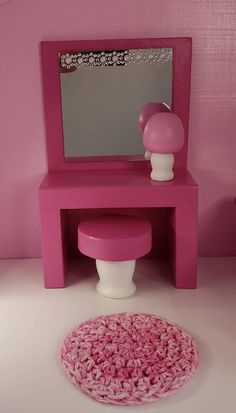 there is a pink vanity and stool in the room