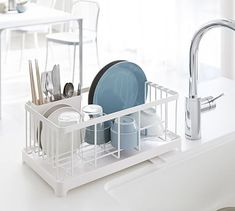 a dish rack with dishes and utensils in it