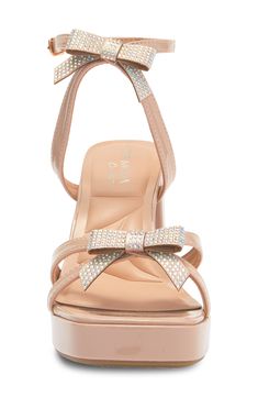 A chunky block heel elevates this party-ready sandal that's topped with slender straps and shimmering with crystallized bows. 3 1/2" heel; 3/4" platform Synthetic upper, lining and sole Imported Synthetic Sandals For Party And Holiday, Party Heels With Bow Straps And Block Heel, Holiday Party Synthetic Sandals, Low Heel Block Heels With Bow For Party, Glamorous Open Toe Heels With Bow Straps, Glamorous Synthetic Heels For Party Season, Synthetic Wedge Heel Block Heels For Evening, Party Sandals With Bow Straps, Synthetic Wedge Heels For Evening