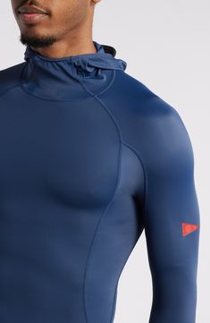 a man wearing a blue wetsuit with an orange patch on the chest