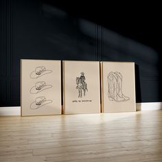 three framed pictures with cowboy boots on them in an empty room next to a wooden floor