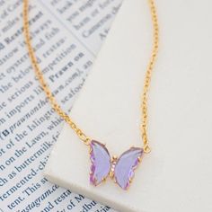 Shine in this playful acrylic butterfly necklace. Features transparent gem tone wings with crystal sparkle body. Measures 16" + 3" extension.Butterfly .5" x .75" Trendy Butterfly Necklaces For Party, Purple Butterfly Charm Jewelry For Party, Butterfly Charm Necklace For Party, Acrylic Butterfly, Gem Tones, Global Village, Butterfly Pendant Necklace, Butterfly Necklace, Butterfly Pendant