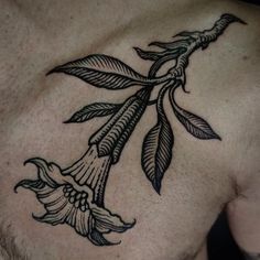 a man's chest with a flower tattoo on it