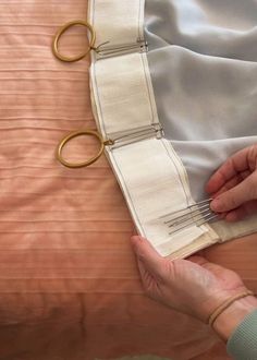 someone is cutting fabric with scissors on a bed sheet that has been made into a pillow