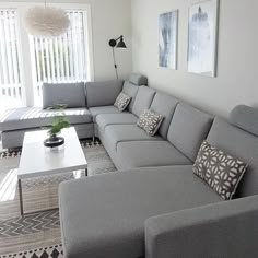 a living room with grey couches and pillows