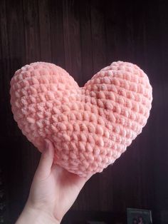 a hand holding a pink heart shaped object